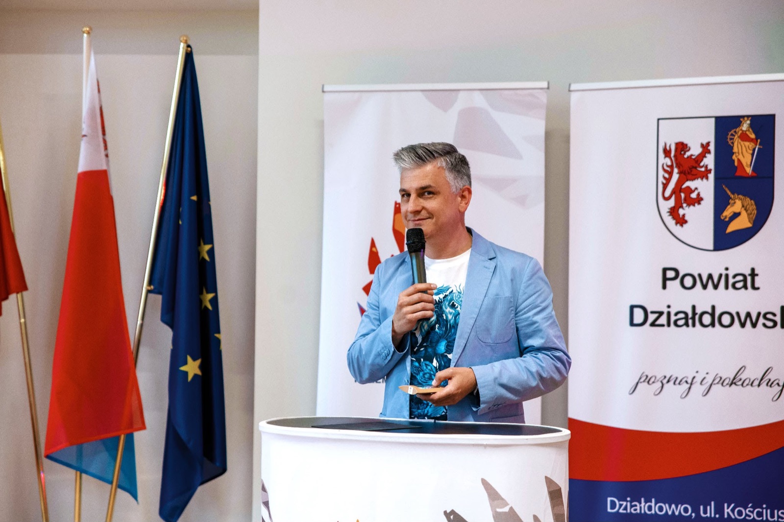 Prowadzący podczas wystąpienia przy mównicy konferencyjnej